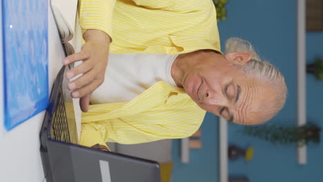 Vertical-video-of-Home-office-worker-old-man-stressed-and-thoughtful.